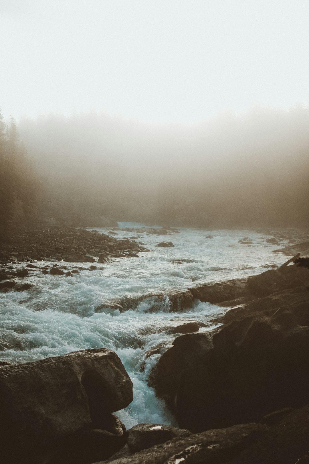 ocean waves crashing on rocks during foggy weather