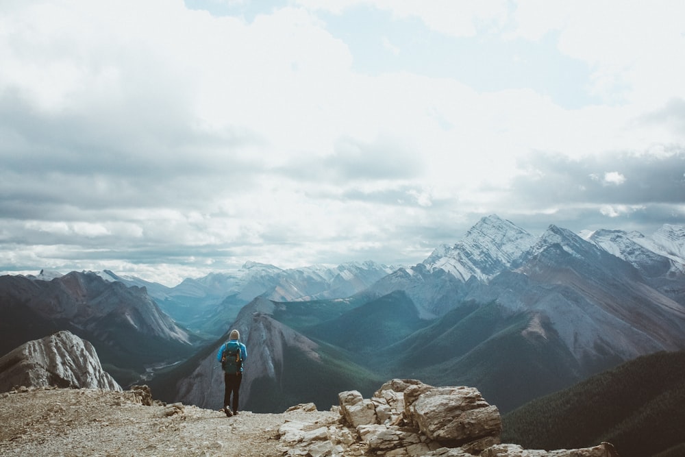 person in black jacket standing on rocky mountain during daytime