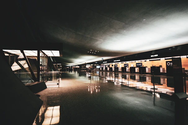 A welcoming international airport terminal bathed in soft purple and orange lighting.
