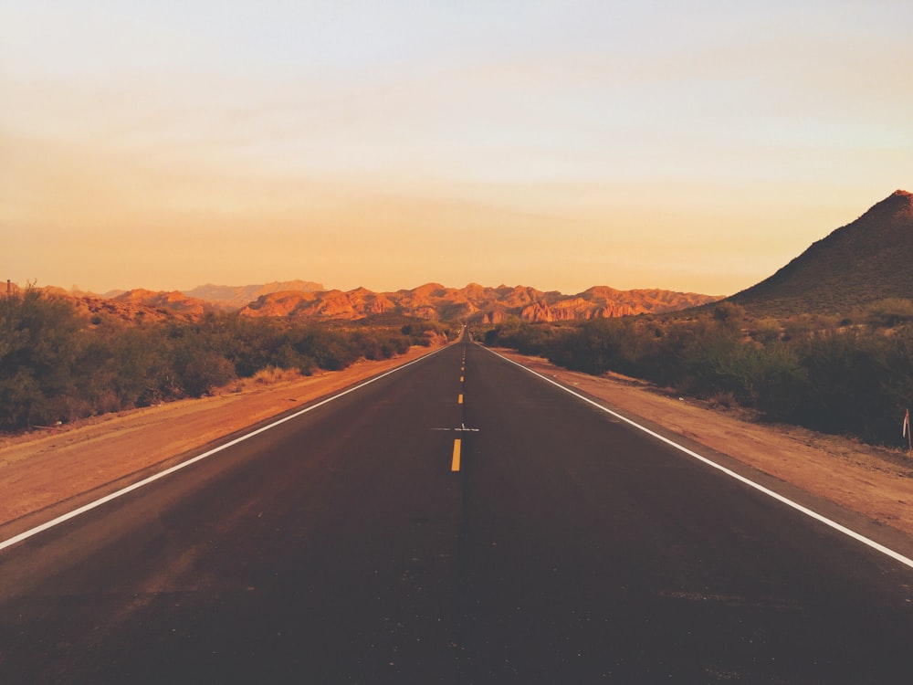 black asphalt road between brown mountains during daytime