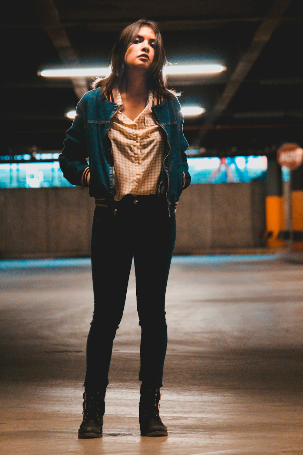 woman in gray jacket and black pants standing on gray pavement