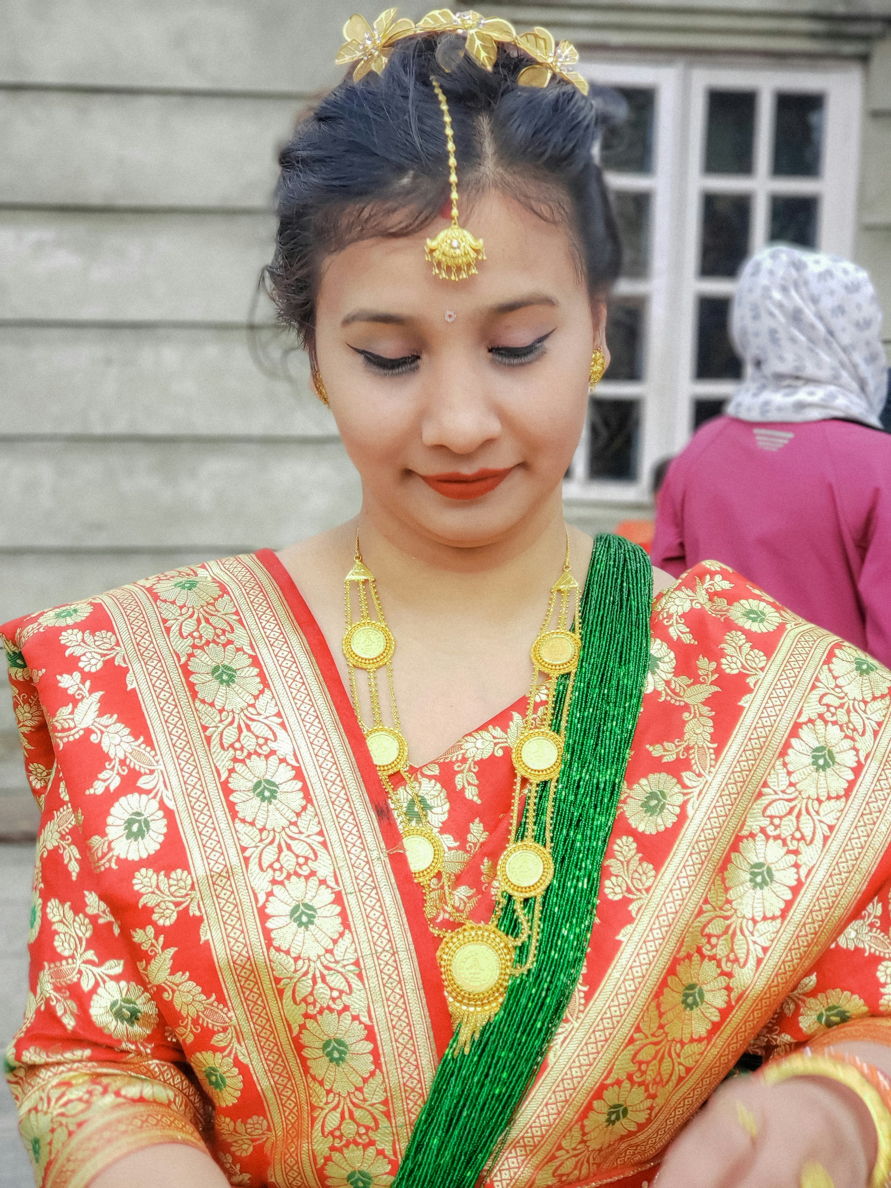 a woman in a red and green dress holding a cell phone