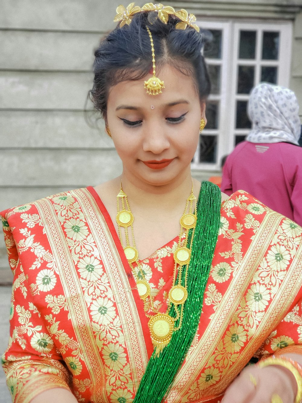 a woman in a red and green dress holding a cell phone