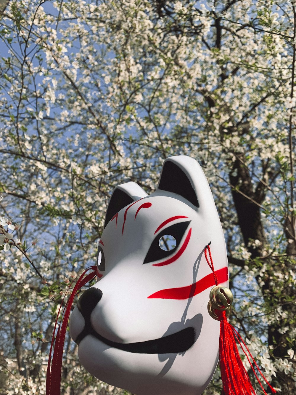 white and black mask near brown tree during daytime