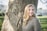 woman in gray crew neck shirt standing beside brown rock