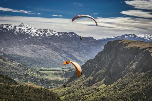 Person in yellow parachute over mountains during daytime — Queenstown, New Zealand