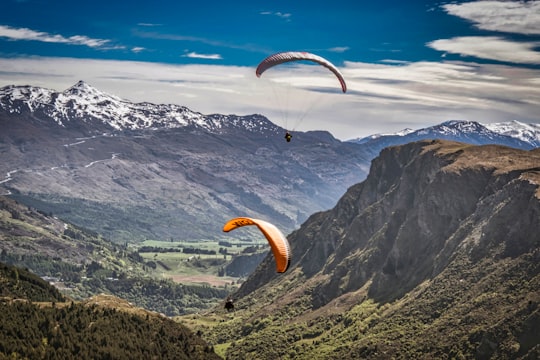 person in yellow parachute over mountains during daytime in Queenstown New Zealand