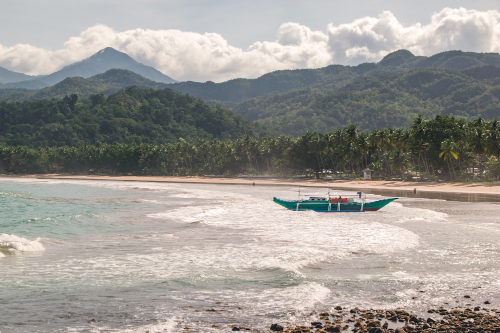 blue and white boat on sea shore during daytime