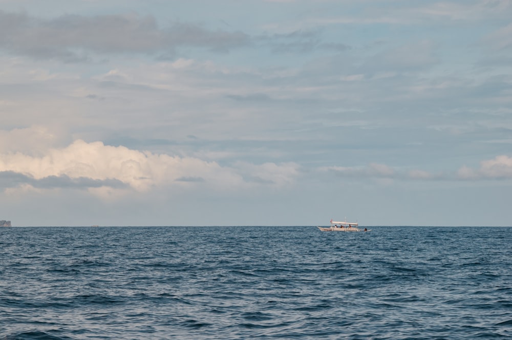 white ship on sea under white clouds during daytime