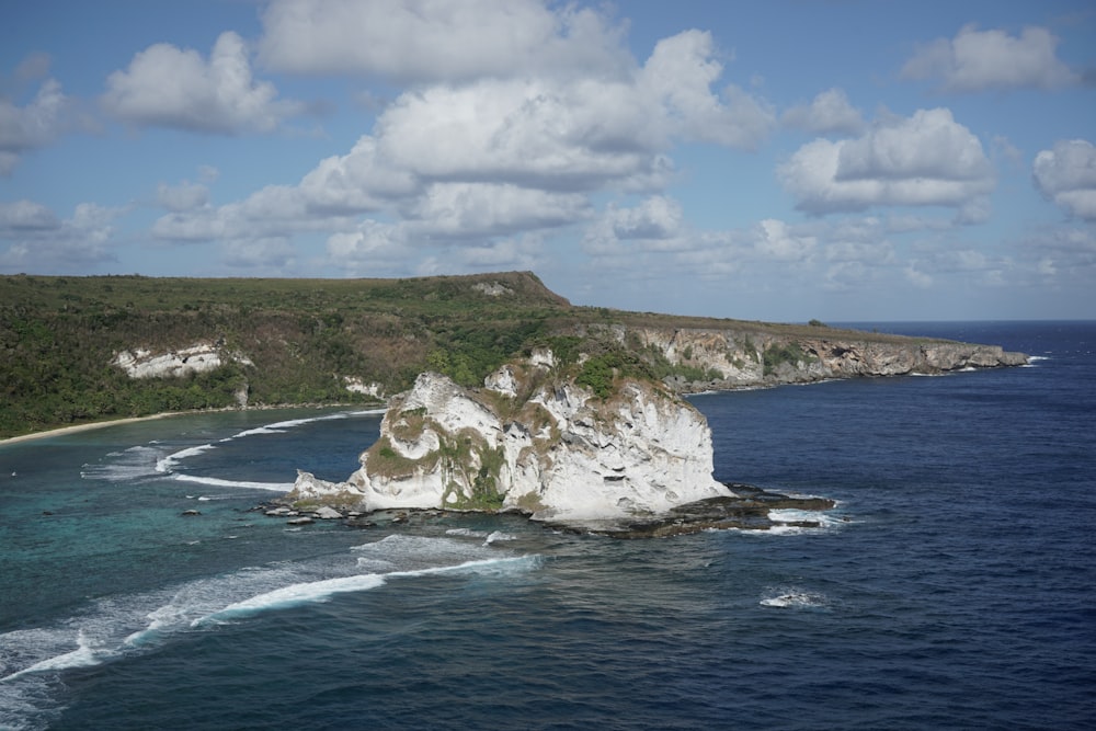 a large body of water next to a lush green hillside