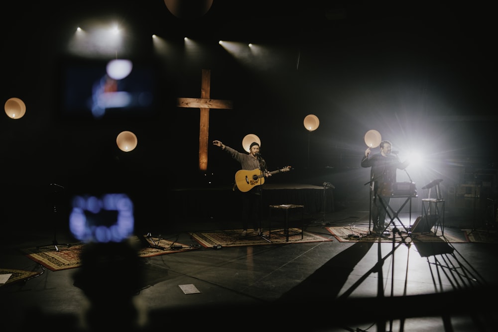 man playing guitar on stage