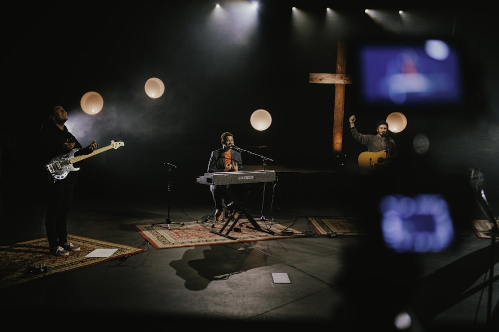 man in black shirt playing piano on stage