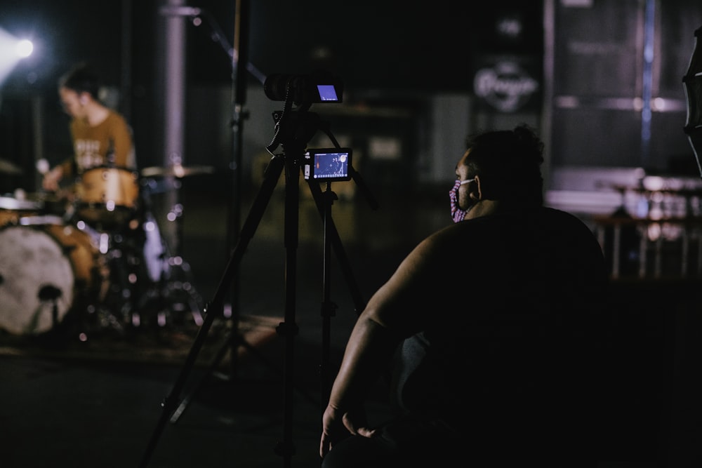 man in black tank top holding black camera