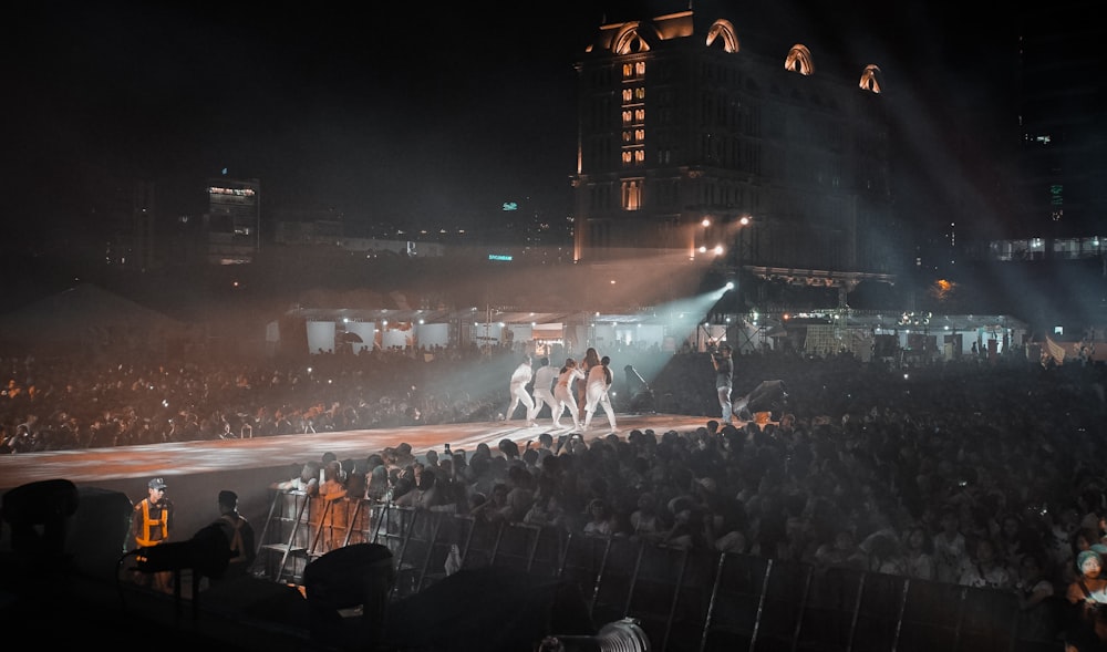 people watching a band performing on stage during nighttime