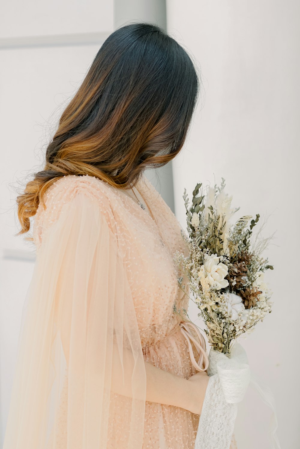 a woman in a dress holding a bouquet of flowers