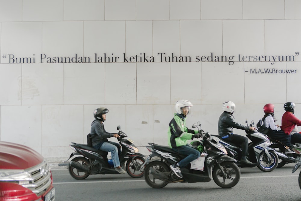 a group of people riding motorcycles down a street