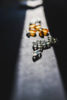 Close-up of sleek black and blue encapsulated supplements with subtle lighting highlighting their texture