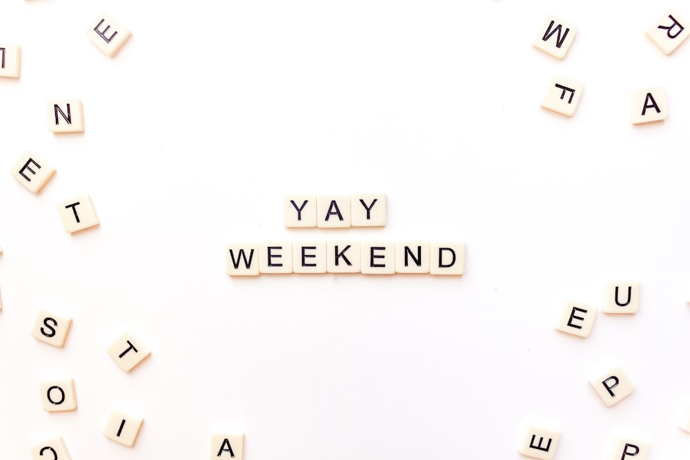 Scrabble-Buchstaben, die das Wort Yay Weekend buchstabieren