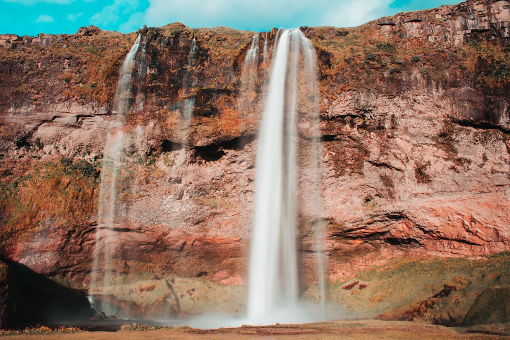 brown rocky mountain with water falls