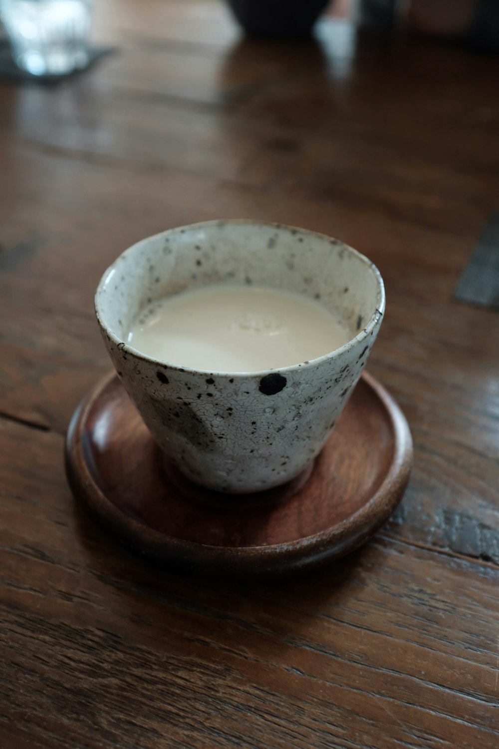 white ceramic cup on brown wooden round coaster