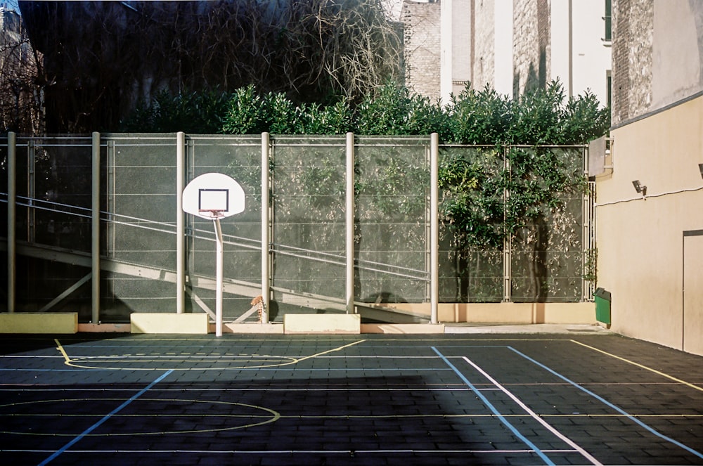 canestro da basket bianco vicino agli alberi verdi durante il giorno