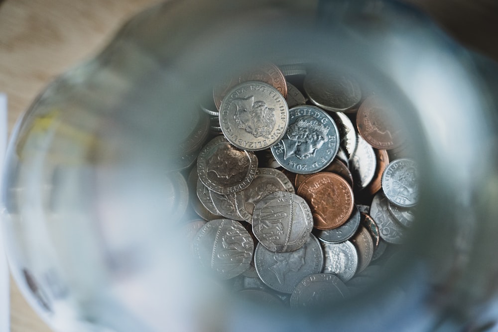 Silberne runde Münzen auf blauem runden Behälter
