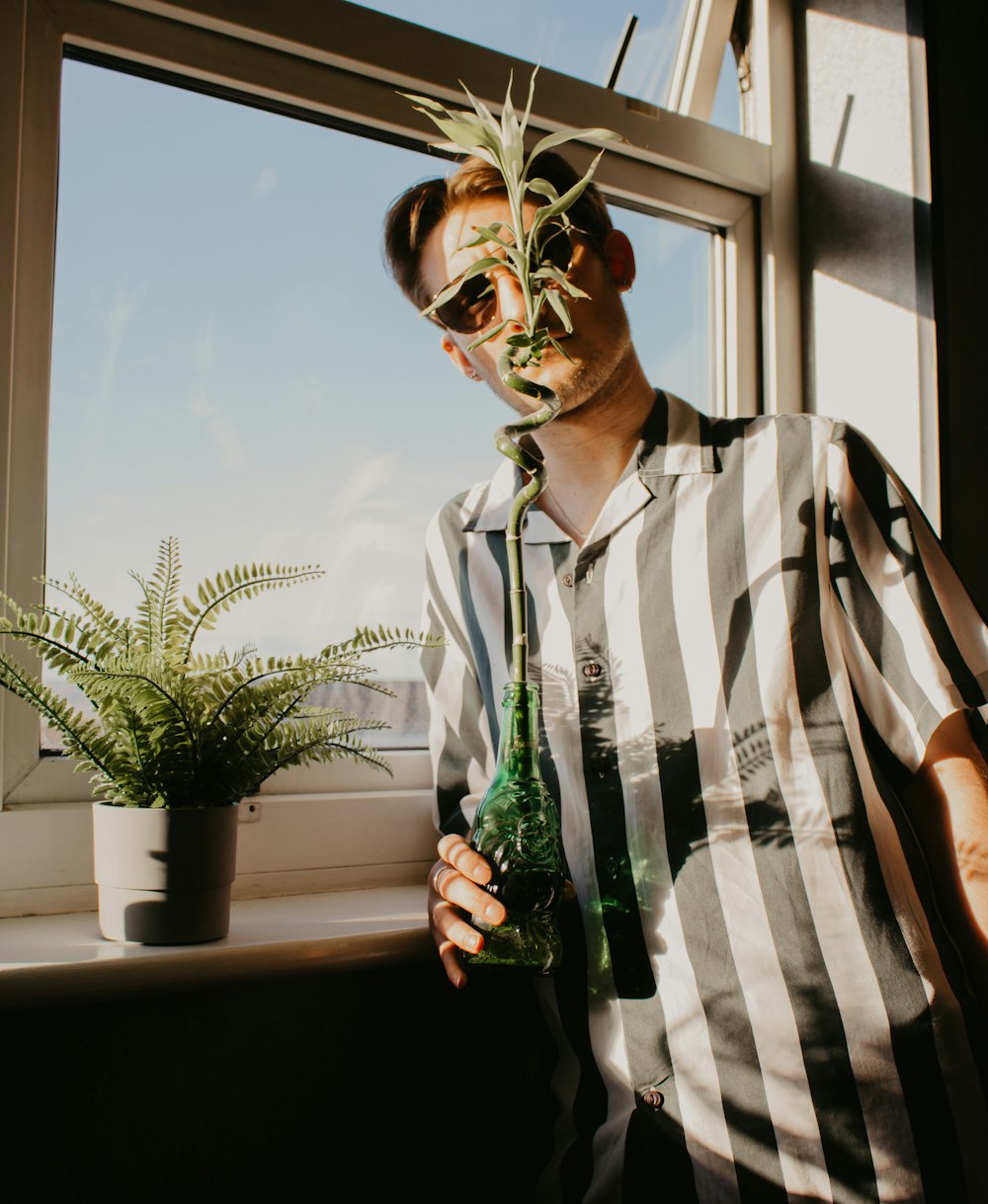 man in white and black stripe button up shirt wearing brown sunglasses