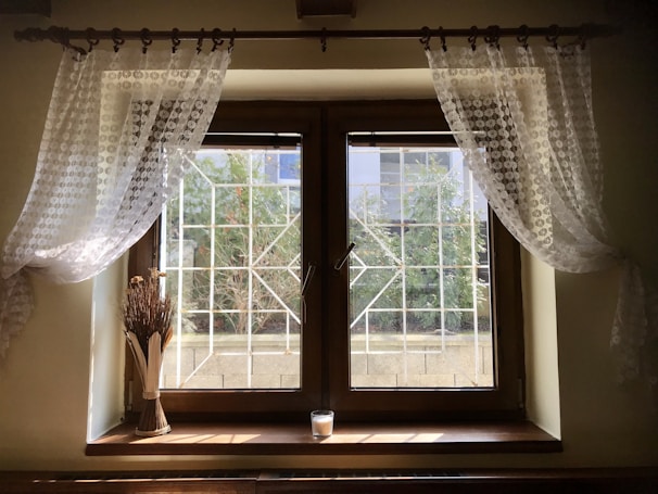 Bright kitchen window framed by crisp, waterproof curtain tiers.
