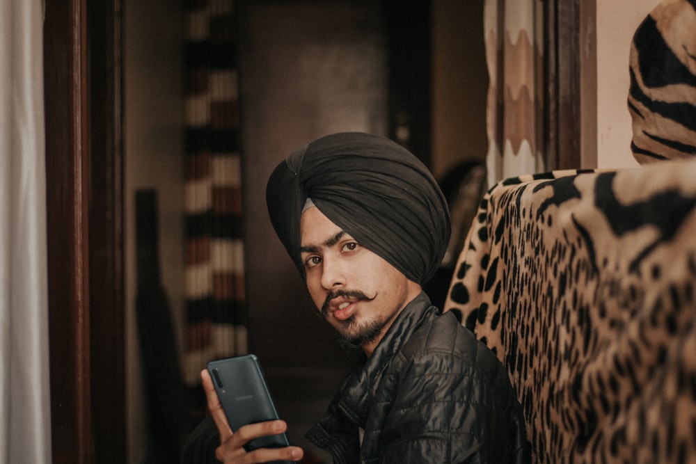 woman in black leather jacket holding black smartphone