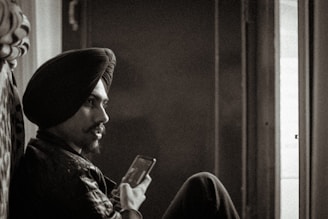 A warm, inviting portrait of a knowledgeable ustadz engaging with a digital device.