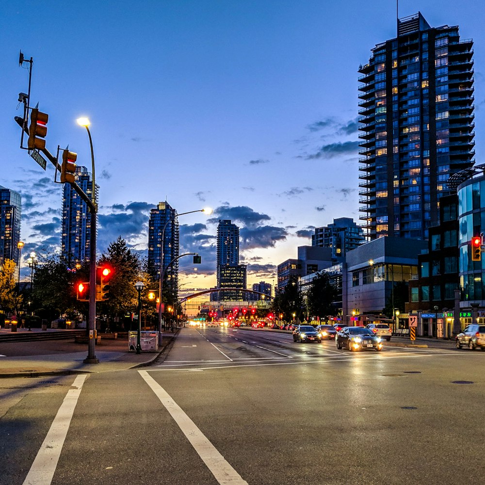 cars on road near high rise buildings during night time