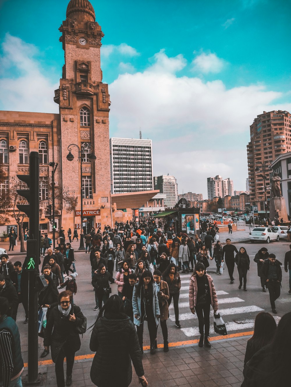 Personas caminando por la calle cerca de un edificio de hormigón marrón durante el día