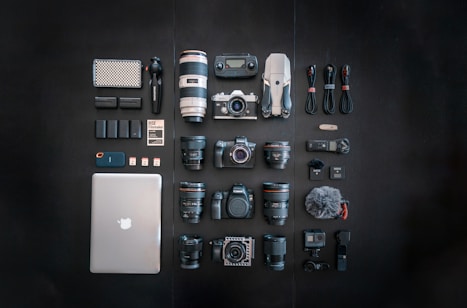 silver macbook black dslr camera and black dslr camera