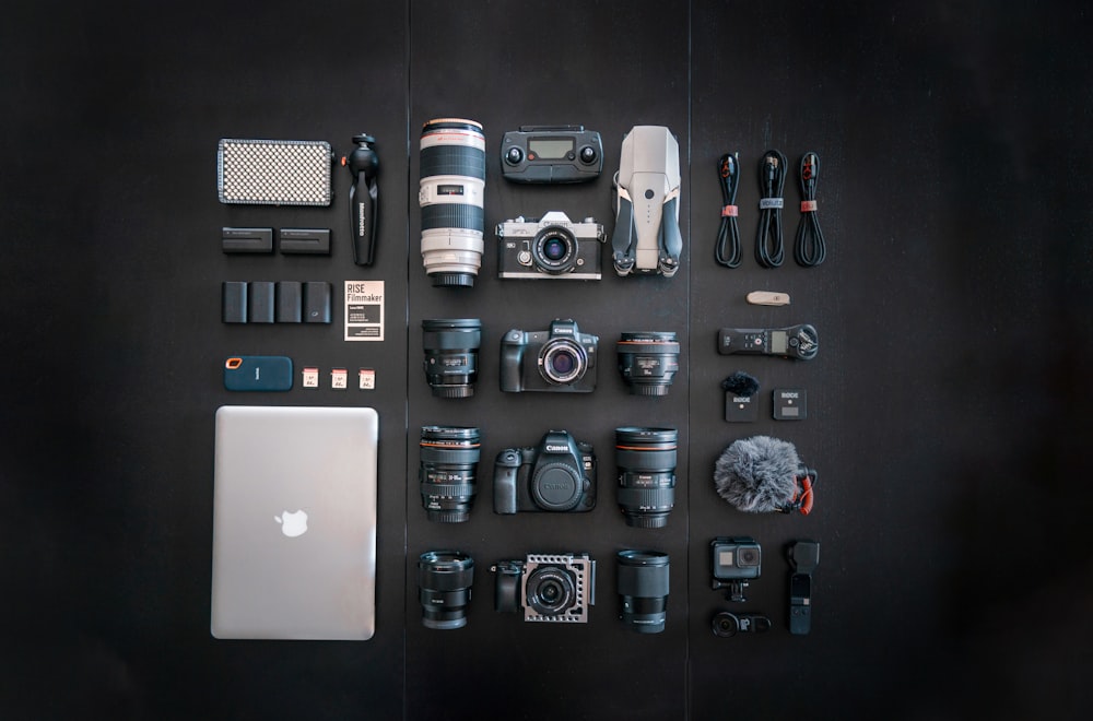 silver macbook black dslr camera and black dslr camera