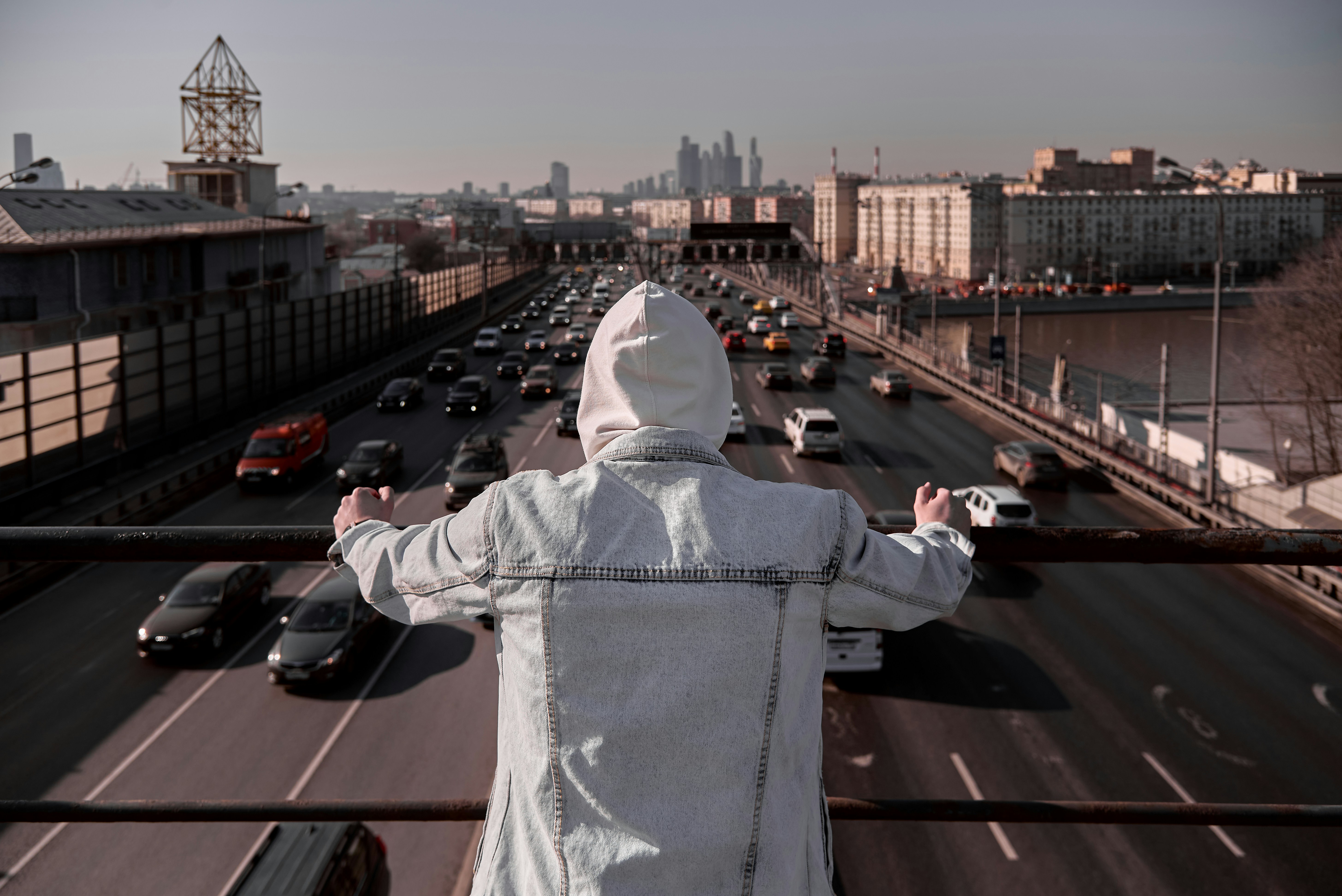 person in white hoodie standing on roof top during daytime