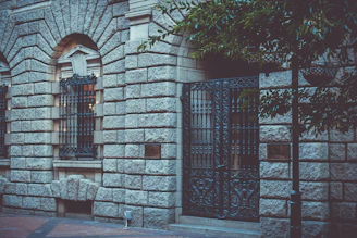 Close-up of the villa's ornate wrought-iron gates and elegant stone facade.