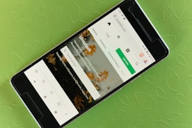 A smartphone displaying a website interface with a prominent green button labeled 'Join free.' The screen shows a search bar and various categories like Editorial, Wallpapers, and Textures & Patterns. The background is a textured, light green surface with a leaf pattern.