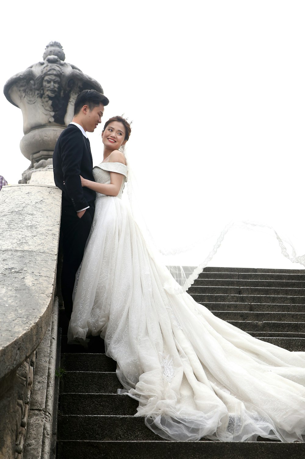 bride and groom standing on concrete stairs