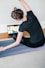 woman in black t-shirt and black pants lying on black yoga mat