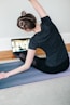 woman in black t-shirt and black pants lying on black yoga mat