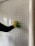 A person wearing a yellow glove is cleaning a white shutter with a green cloth. The shutter has horizontal slats and some light peeks through.