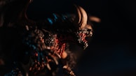 An intense close-up of a dragon figurine breathing fire, showcasing sharp scales.