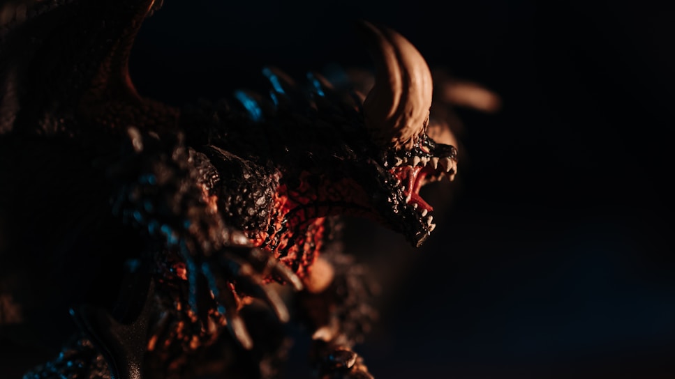 Close-up of a detailed 3D creature with textured scales and glowing eyes in a dark fantasy setting