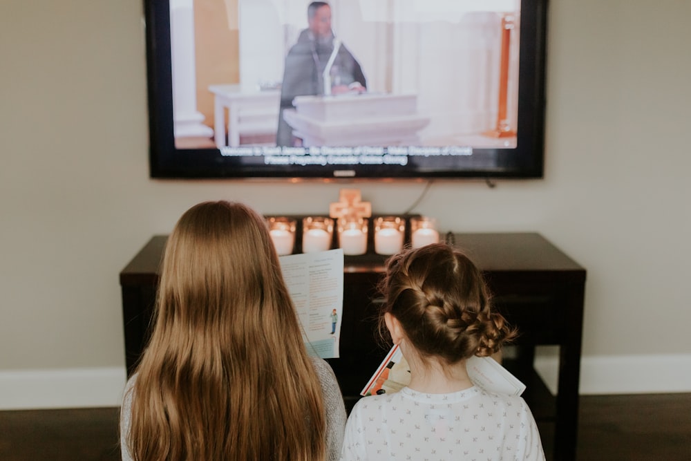 girl in white and black polka dot shirt watching tv