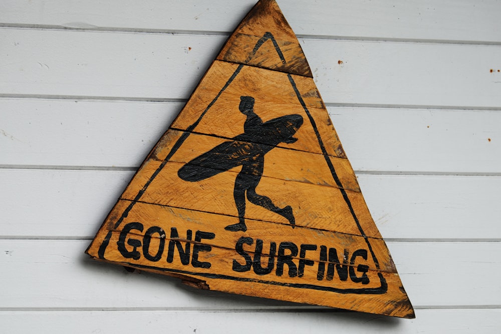 a wooden sign that says gone surfing on it