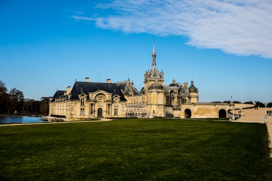 beige concrete building under blue sky during daytime in Château de Chantilly France