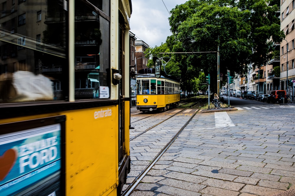 yellow and black tram on road near buildings during daytime