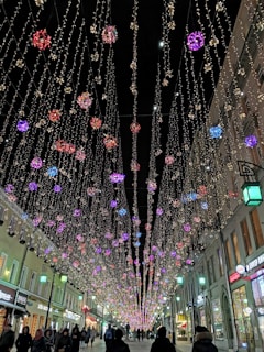 A festive display of Christmas lights illuminating a small town street.