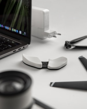 black and silver laptop computer beside white and black frame eyeglasses