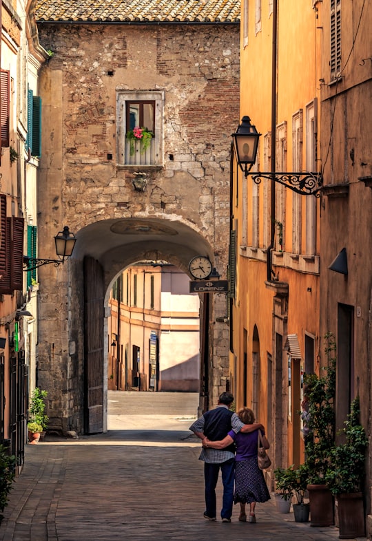 woman in blue jacket sitting on sidewalk during daytime in Amelia Italy